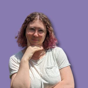 Photo of Phoebe, the face behind RichReads Blog, wearing a white shirt with a purple background.